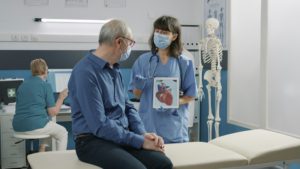 Female assistant holding tablet with cardiovascular system